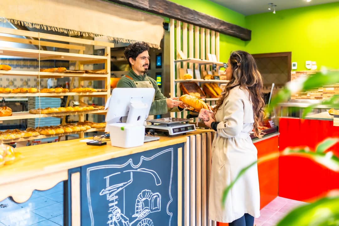 salesman-giving-bread-to-a-client-in-an-artisan-ba-2024-12-10-03-32-11-utc