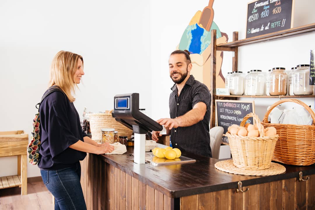 smiling-woman-checking-out-at-a-small-grocery-stor-2025-01-09-03-23-30-utc