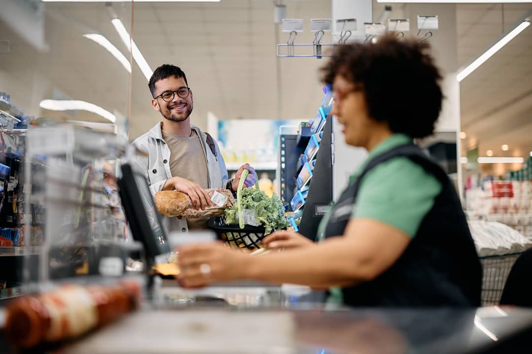 young-happy-man-with-groceries-at-checkout-in-the-2024-12-13-18-19-14-utc